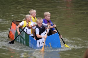 Emily Heim, 11, clockwise from left, her cousin Isaac Heim, 10, their friend Evan Gress, 13, and Isaac's brother Noah, 13, all of Jasper, rowed their boat down the Patoka River during the Holy Family School Patoka Cardboard Boat Regatta in Jasper on Saturday. They made their boat that morning.