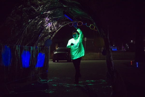 A runner smacks the top of the tunnel set up near A Kid's Place daycare as he passes through.