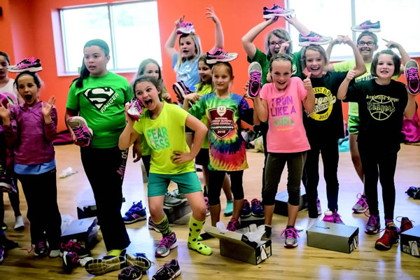 Southeast Dubois School Corporation third through fifth graders are ecstatic about the new shoes they just received as part of the Girls on the Run non-profit program they participate in. Girls on the Run not only gets the youngsters out exercising but also teaches valuable life lessons as well. Here, the girls clown/ pose with their new kicks Thursday after school at the Tri-County YMCA. Photo by Eric Tretter, Ferdinand News