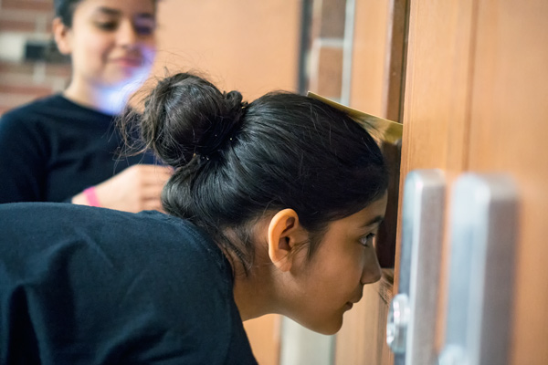 Anahi Loya, 12, peeked through the door to the middle school amphitheatre waiting for her group's cue to enter. 