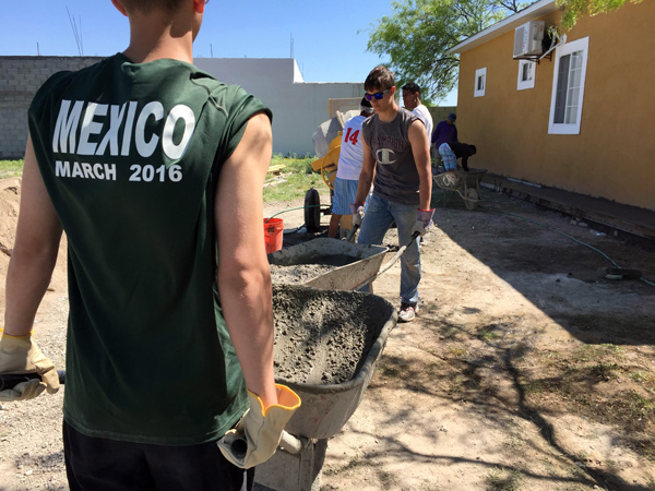 Nolan Harmon and Matthew Rottet hauled concrete by hand to build a curbed flower bed during a mission trip to Piedras Negras, Mexico during Spring Break.