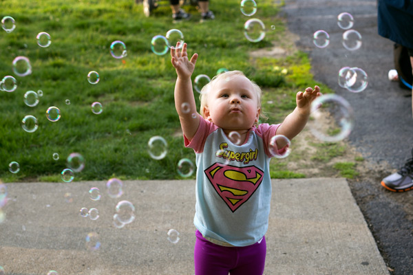 Caroline Ziegler, 15 months, enjoyed the bubble machine during the R.I.D.G.E. Superhero Fun Run Friday evening.