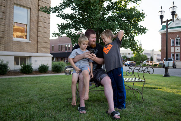 Tony Childree of Huntinggburg and his nephews, Bryson and Jayden Childree, sat on the bench at the courthouse playing Pokemon Go Sunday evening.