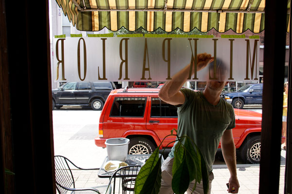 Aaron Catt scrapes bubbles from the new sign on the Fourth Street cafe formerly known as Cool Beans.
