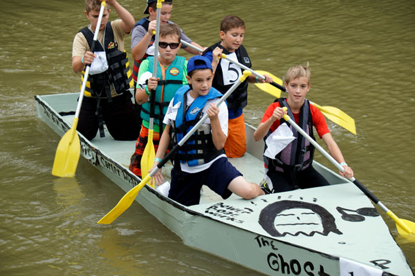 Holy Trinity Catholic School students Mitchell Werner, 13, Jax Bower, 11, Ben Schitter, 11, Matthew Sternberg, 11, Wyatt Troutman, 11, and Carter Mundy, 12, all of Jasper, celebrated after winning the community division of the annual Holy Trinity Cardboard Boat Regatta in the Patoka River at the Dave Buehler Plaza in Jasper on Saturday.