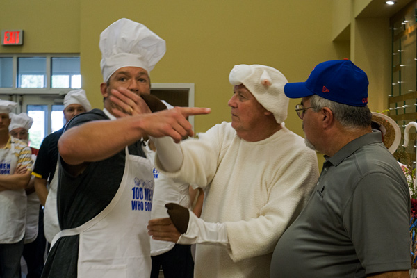 Scott Rolen and OFS Brands CEO Hank Menke (who served lamb) attempted to work out the instructions for the cooks' parade entrance to the event while Tim Robinette looked on.