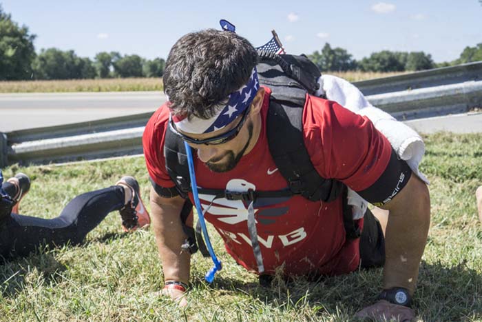 Jeff Durlauf performed a burpee with the group at the end of the 11-mile walk near the Veterans Memorial Bridge in Jasper. Durlauf helped with planning the commemorative walk.