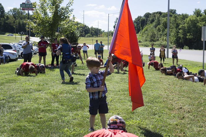 Tristan Atkins, 4, held the Team Red, White & Blue flag as his dad Craig Atkins performed the burpees. Atkins served 12 years in the U.S. Marine Corps. He carried the team's flag at the head of the procession all 11 miles. 